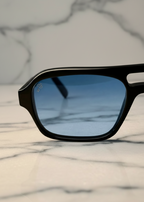 Ocean Breeze blue lens sunglasses by Valenti Exclusive, front close up view on marble background