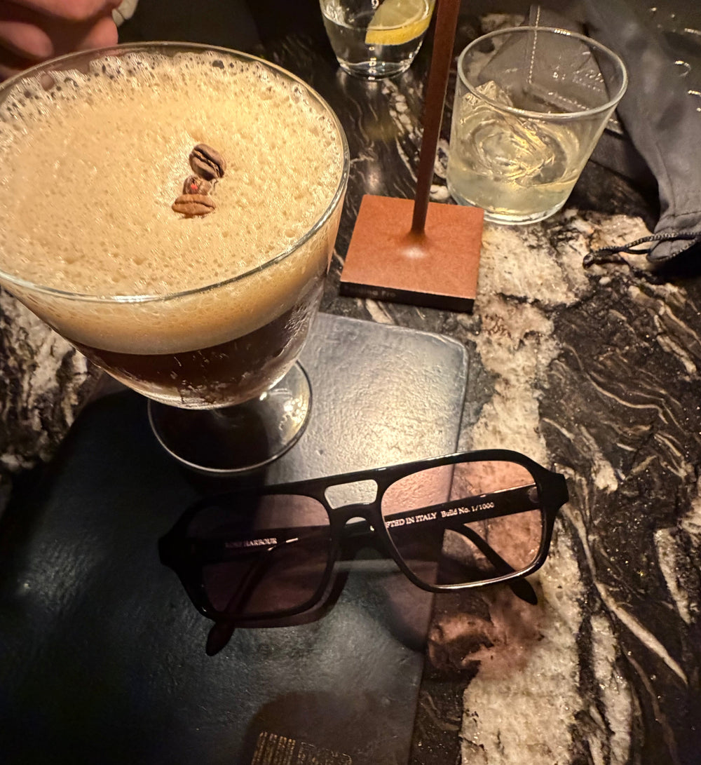 Rose Harbour sunglasses in a high end bar with whiskey and a Cocktail 
